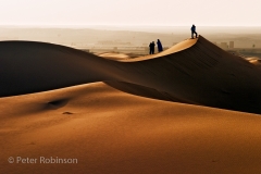 Erg Chebbi sand dunes with a man on a peak sahara desert morocco